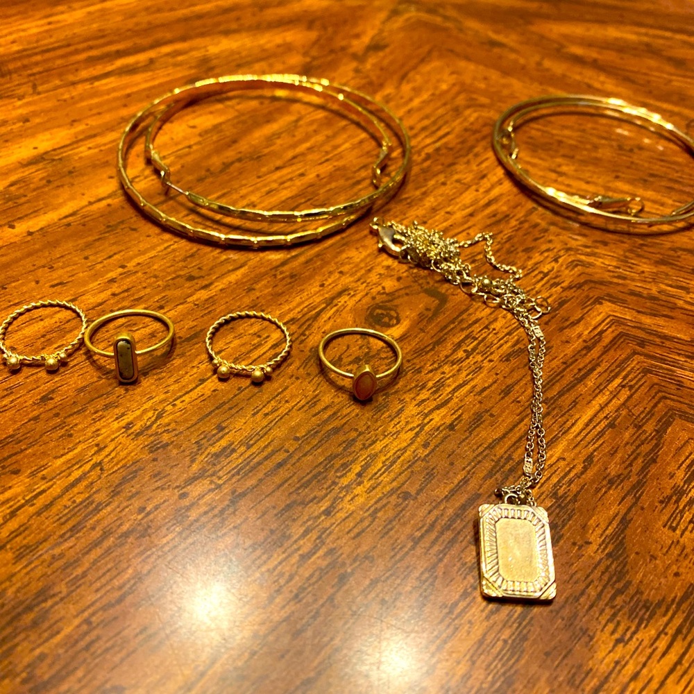 4 rings, 2 necklaces, 2 hoop earrings and a bracelet